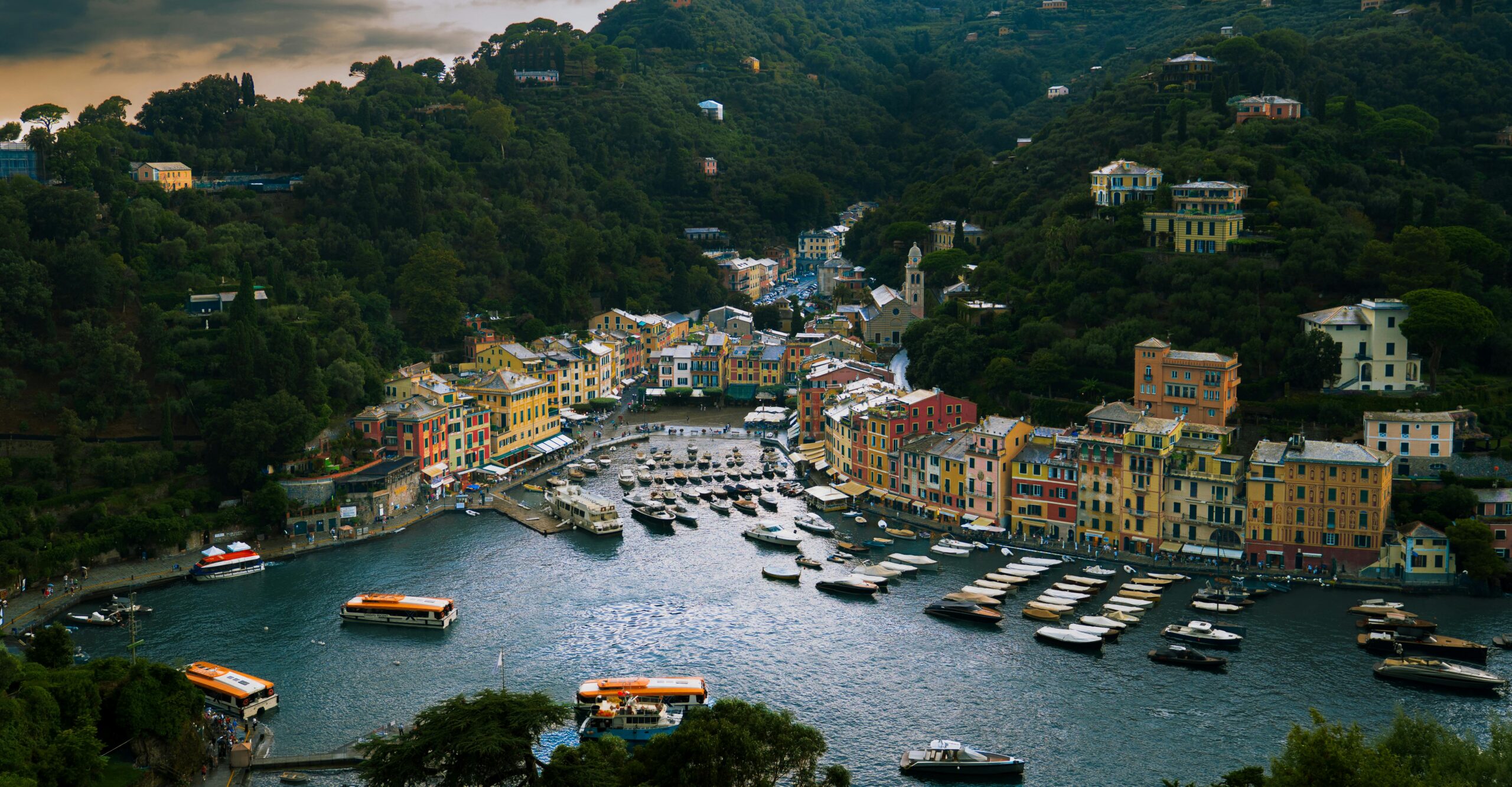 A vibrant view of Portofino harbor with colorful buildings and boats in Liguria, Italy.