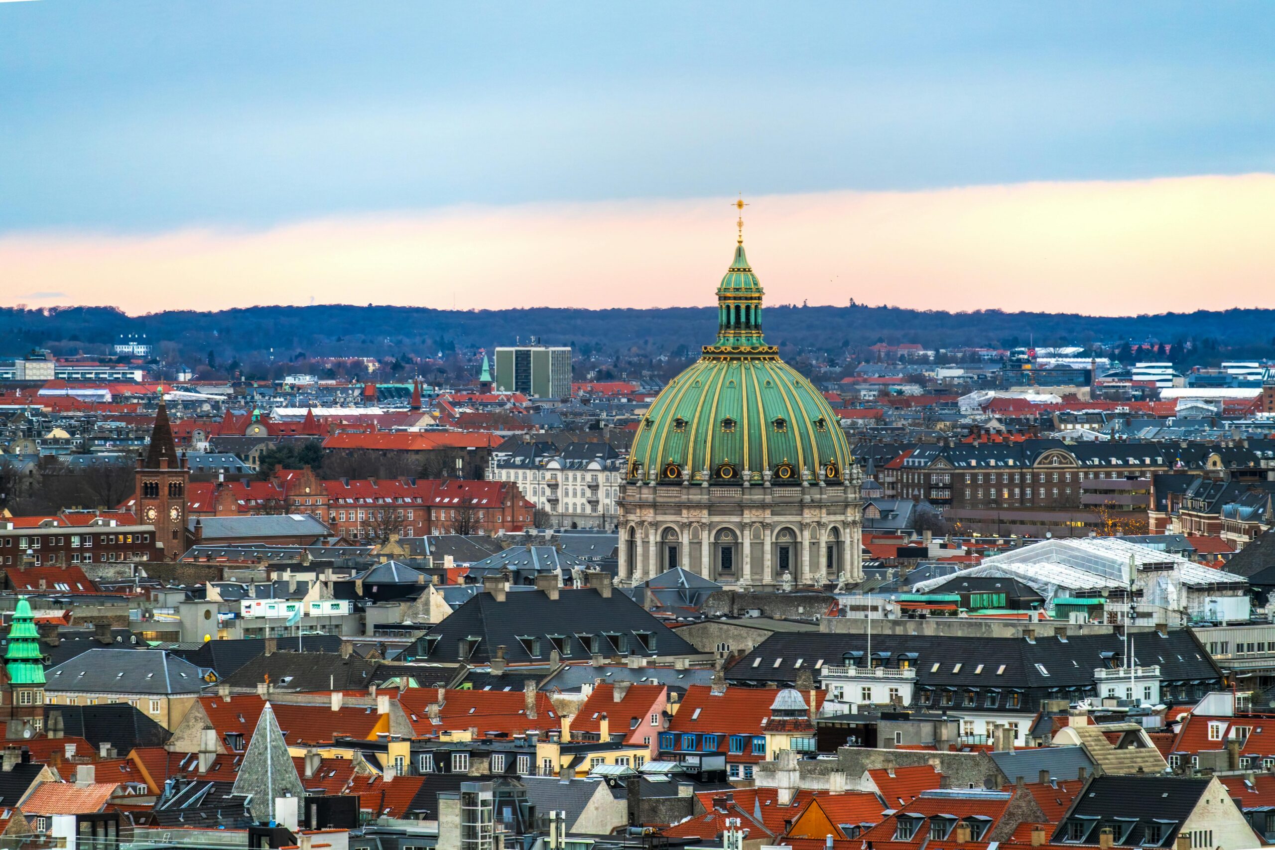 Stunning aerial view of Frederik's Church and Copenhagen skyline at sunset with iconic architecture.